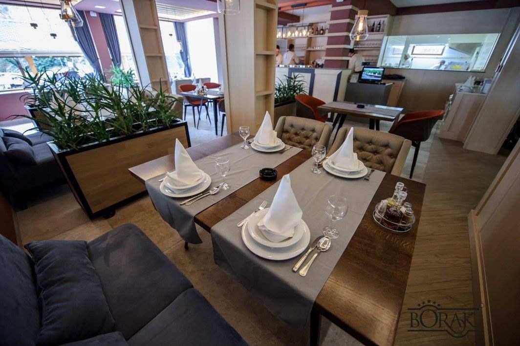 Rustikalni interijer restorana s toplim drvenim i kamenim motivima